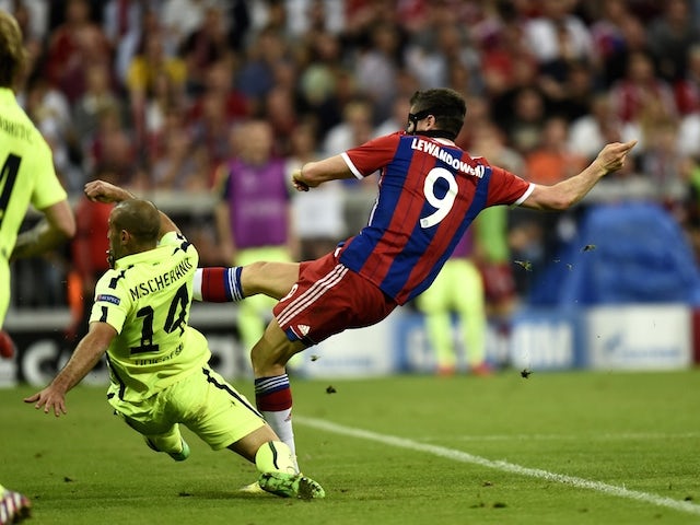 Bayern Munich's Polish forward Robert Lewandowski (R) shoots to score during the UEFA Champions League football match semi final FC Bayern Munich vs FC Barcelona in Munich on May 12, 2015
