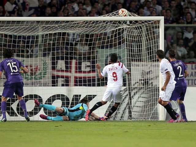 Carlos Bacca #9 of FC Sevilla scores the opening goal during the UEFA Europa League Semi Final match between ACF Fiorentina and FC Sevilla on May 14, 2015