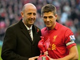 Liverpool's English midfielder Steven Gerrard receives an award from former captain Gary McAllister to mark his 600th appearance for the club before the English Premier League football match between Liverpool and Newcastle United at Anfield in Liverpool, 