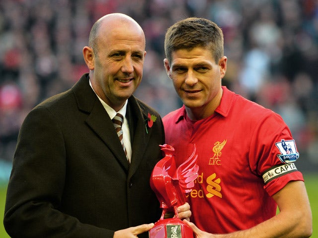 Liverpool's English midfielder Steven Gerrard receives an award from former captain Gary McAllister to mark his 600th appearance for the club before the English Premier League football match between Liverpool and Newcastle United at Anfield in Liverpool, 