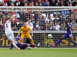 Gylfi Sigurdsson of Swansea City scores a goal despite the challenge from Martin Demichelis of Manchester City during the Barclays Premier League match between Swansea and Manchester City at the Liberty Stadium on May 17, 2015