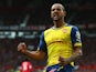 Theo Walcott of Arsenal celebrates as his cross deflects off of Tyler Blackett of Manchester United for an own goal during the Barclays Premier League match between Manchester United and Arsenal at Old Trafford on May 17, 2015
