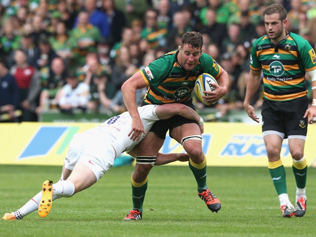 Calum Clark of Northampton is tackled by Owen Farrell during the Aviva Premiership play off semi final match between Northampton Saints and Saracens at Franklin's Gardens on May 23, 2015
