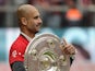 Bayern Munich's Spanish head coach Pep Guardiola holds the trophy as his team celebrates wining their 25th Bundesliga title after German first division Bundesliga football match FC Bayern Munich vs 1 FSV Mainz 05 at the Allianz Arena in Munich, southern G