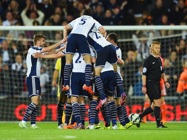 Chris Brunt of West Bromwich Albion (obscured) is mobbed by team mates in celebration as he scores their third goal during the Barclays Premier League match between West Bromwich Albion and Chelsea at The Hawthorns on May 18, 2015