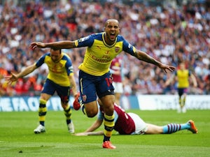 Theo Walcott wheels away in celebration after scoring the opening goal of the FA Cup final at Wembley between Arsenal and Aston Villa on May 30, 2015