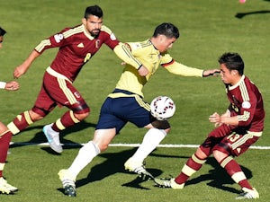 Colombia's midfielder James Rodriguez (C) is marked by Venezuela's Tomas Rincon and Luis Seijas (R) during their 2015 Copa America football championship match, in Rancagua, Chile, on June 14, 2015