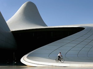 A boy rides a bicycle past the Heydar Aliyev Cultural Center ahead of Baku 2015, the first European Games on June 11, 2015