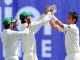 Pakistan cricketer Yasir Shah (R) and teammates celebrate the dismissal of Sri Lankan cricketer Rangana Herath during the final day of the opening Test match between Sri Lanka and Pakistan at the Galle International Cricket Stadium in Galle on June 21, 20