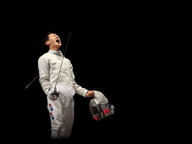 Bongil Gu of Korea celebrates against Tiberiu Dolniceanu of Romania during the Men's Sabre Team Fencing on Day 7 of the London 2012 Olympic Games at ExCeL on August 3, 2012