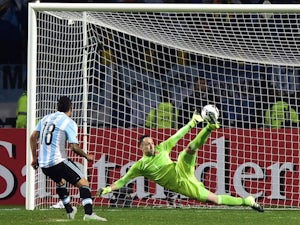 Argentina's forward Carlos Tevez (L) scores the winning penalty kcik past Colombia's goalkeeper David Ospina during the 2015 Copa America football championship quarterfinal match in Vina del Mar, Chile on June 26, 2015