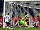 Argentina's forward Carlos Tevez (L) scores the winning penalty kcik past Colombia's goalkeeper David Ospina during the 2015 Copa America football championship quarterfinal match in Vina del Mar, Chile on June 26, 2015