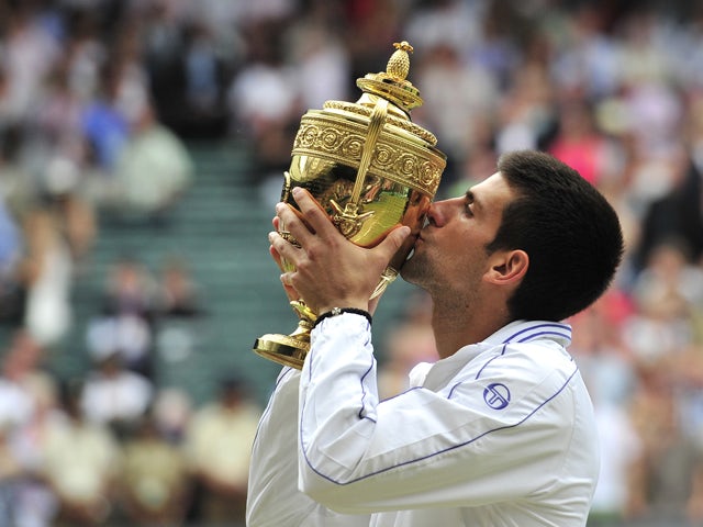 Serbian player Novak Djokovic kisses the trophy after beating Spanish player Rafael Nadal in the men's single final at the Wimbledon Tennis Championships at the All England Tennis Club, in southwest London on July 3, 2011