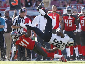 Travaris Cadet #39 of the New Orleans Saints gets tripped up along the sideline by C.J. Wilson #41 of the Tampa Bay Buccaneers in the second half of the game at Raymond James Stadium on December 28, 2014