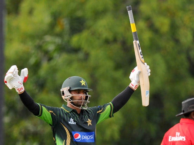 Pakistan cricketer Mohammad Hafeez raises his bat in celebration after scoring a century (100 runs) during the first One Day International (ODI) match between Sri Lanka and Pakistan at the Rangiri Dambulla International Cricket stadium in Dambulla, some 1
