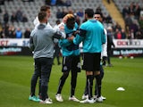Olivier Kemen of Newcastle United talks with team mate Jonas Gutierrez (R) prior to the Barclays Premier League match between Newcastle United and Arsenal at St James' Park on March 21, 2015