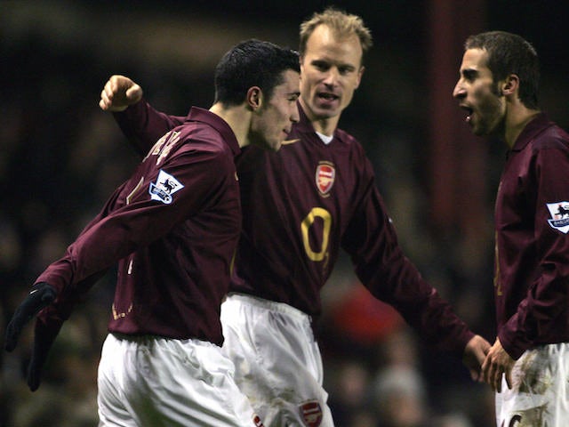 Arsenal's Robin Van Persie (L) celebrates his goal against Wigan with Dennis Bergkamp (C) and Mathieu Flamini during their Carling Cup match at Arsenal's grounds, 24 January 2006