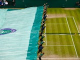 The covers come on during a rain break in the Final Of The Gentlemen's Singles between Novak Djokovic of Serbia and Roger Federer of Switzerland on day thirteen of the Wimbledon Lawn Tennis Championships at the All England Lawn Tennis and Croquet Club on 