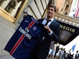 Soccer player Benjamin Stambouli holds up his new jersey from team Paris Saint-Germain July 23, 2015