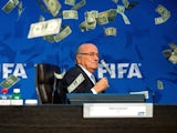 Sepp Blatter is showered in fake money at a FIFA press conference on July 20, 2015