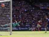 Chelsea's Belgian goalkeeper Thibaut Courtois (L) cannot stop the shot from Arsenal's English midfielder Alex Oxlade-Chamberlain (2nd R) giving Arsenal the lead during the FA Community Shield football match between Arsenal and Chelsea at Wembley Stadium i
