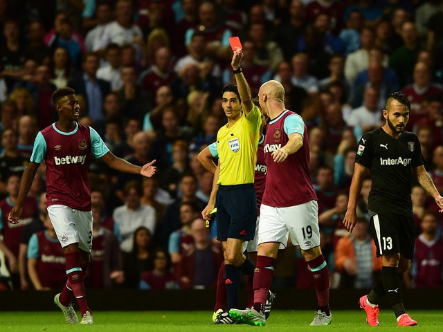 James Collins of West Ham is being shown a red card by Referee, Adrien Jaccottet during the UEFA Europa League third qualifying round match between West Ham United and Astra Giurgiu at the Boleyn Ground on July 30, 2015