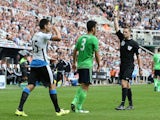 Newcastle United's Serbian striker Aleksandar Mitrovic (L) receives a yellow card by referee Craig Pawson (R) shortly after coming on during the English Premier League football match between Newcastle United and Southampton at St James' Park in Newcastle-