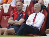 Arsenal's French manager Arsene Wenger (C) sits on the bench watching the action during the English Premier League football match between Arsenal and West Ham United at the Emirates Stadium in London on August 9, 2015
