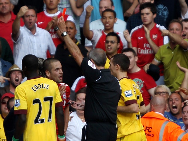 Referee Martin Atkinson shows a red card to Joe Cole of Liverpool during the Barclays Premier League match between Liverpool and Arsenal at Anfield on August 15, 2010