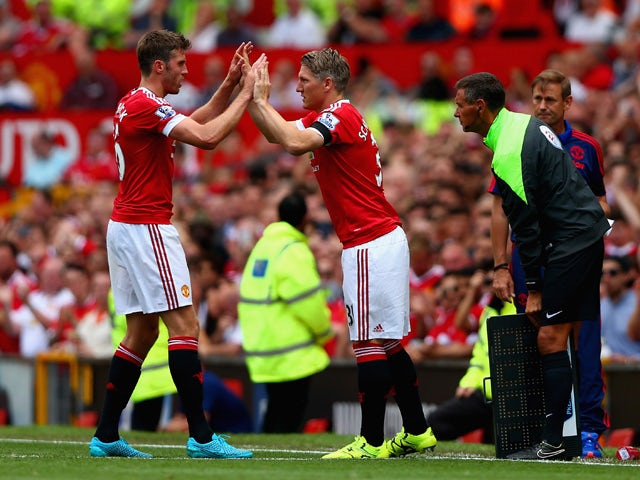 Bastian Schweinsteiger of Manchester United high fives with his team mate Michael Carrick during the Barclays Premier League match between Manchester United and Tottenham Hotspur at Old Trafford on August 8, 2015