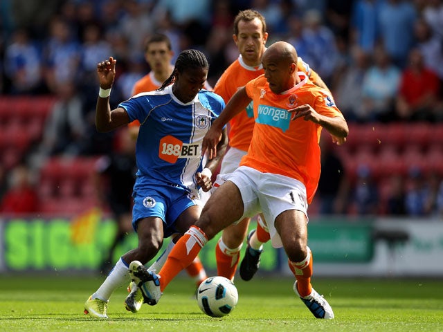 Hugo Rodallega of Wigan Athletic is challenged by Alex Baptiste of Blackpool during the Barclays Premier League match between Wigan Athletic and Blackpool at the DW Stadium on August 14, 2010