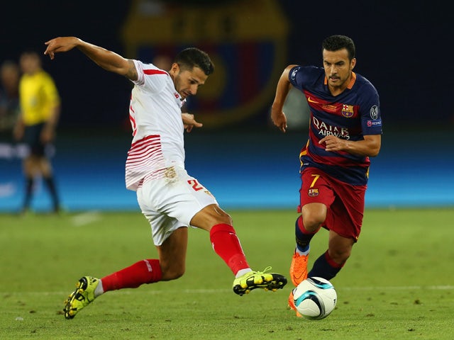 Pedro of Barcelona evades a tackle from Vitolo of Sevilla during the UEFA Super Cup between Barcelona and Sevilla FC at Dinamo Arena on August 11, 2015