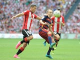 Andres Iniesta of FC Barcelona is tackled by Oscar de Marcos of Athletic Club during the La Liga match between Athletic Club and FC Barcelona at San Mames Stadium on August 23, 2015