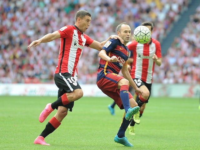 Andres Iniesta of FC Barcelona is tackled by Oscar de Marcos of Athletic Club during the La Liga match between Athletic Club and FC Barcelona at San Mames Stadium on August 23, 2015