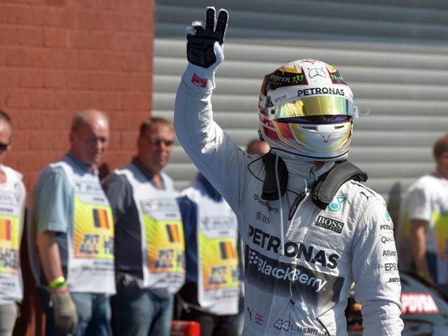 Mercedes AMG Petronas F1 Team's British driver Lewis Hamilton waves after taking the pole position in the pits after the qualifying session at the Spa-Francorchamps ciruit in Spa on August 22, 2015
