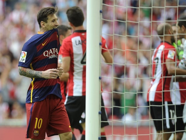 Barcelona's Argentinian forward Lionel Messi (L) bites his shirt after missing a penalty during the Spanish league football match Athletic Club Bilbao vs FC Barcelona at the San Mames stadium in Bilbao on August 23, 2015