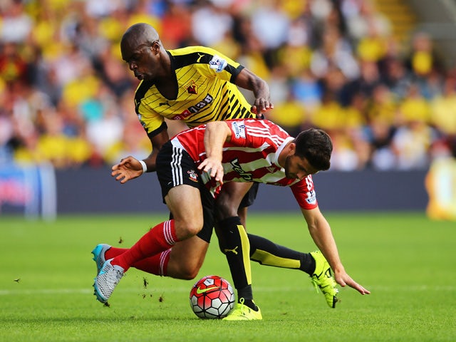 Shane Long of Southampton is challenged by Allan-Romeo Nyom of Watford during the Barclays Premier League match between Watford and Southampton at Vicarage Road on August 23, 2015