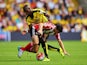 Shane Long of Southampton is challenged by Allan-Romeo Nyom of Watford during the Barclays Premier League match between Watford and Southampton at Vicarage Road on August 23, 2015