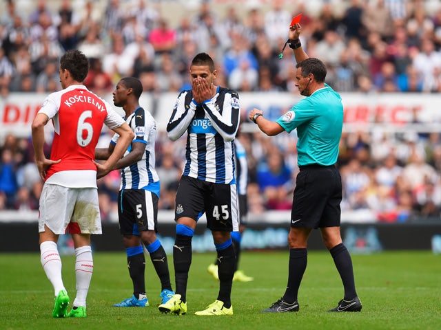 Aleksandar Mitrovic of Newcastle United is shown a red card by referee Andre Marriner (1st R) during the Barclays Premier League match between Newcastle United and Arsenal at St James' Park on August 29, 2015