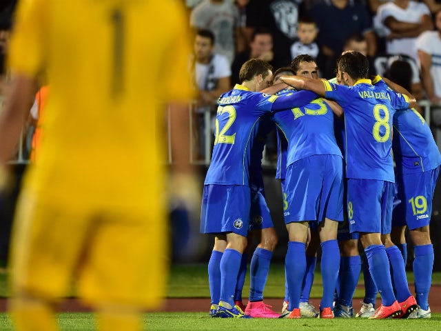 Bate Borisov's midfielder Igor Stasevich (hidden) and his team mates celebrate after scoring a goal during the UEFA Champions League playoff football match between FK Partizan and FC BATE Borisov at FK Partizan stadium in Belgrade on August 26, 2015.