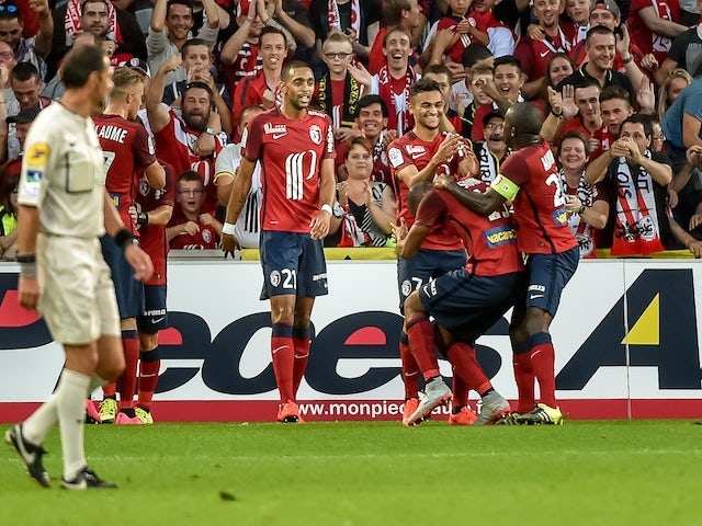 Lille's French midfielder Sofiane Boufal (C) is congratuled by his teammate after scoring a goal during the French L1 football match Lille vs Ajaccio on August 29, 2015