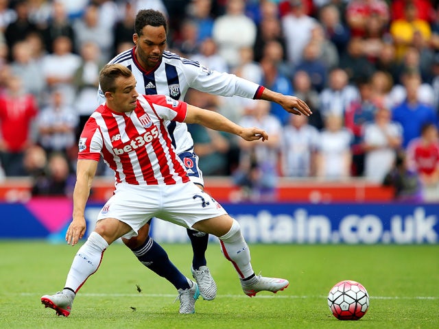 Xherdan Shaqiri of Stoke City and Joleon Lescott of West Bromwich Albion compete for the ball during the Barclays Premier League match between Stoke City and West Bromwich Albion at Britannia Stadium on August 29, 2015