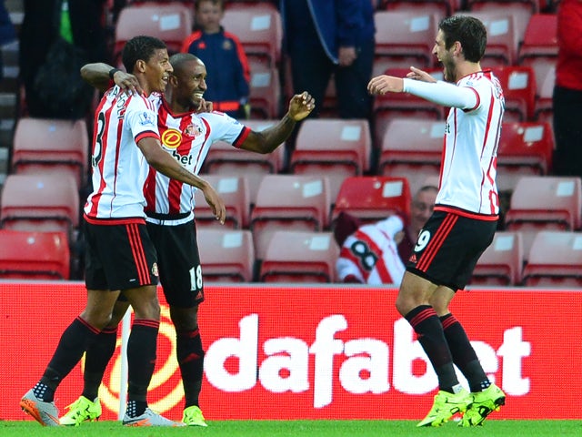 Jermain Defoe of Sunderland celebrates scoring the opening goal with team mate Patrick Van Anholt during the Capital One Cup Second Round match between Sunderland and Exeter City at Stadium of Light on August 25, 2015
