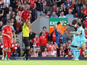 West Ham United's English midfielder Mark Noble receives a red card from referee Kevin Friend for a challenge on Liverpool's English striker Danny Ings (Below L) during the English Premier League football match between Liverpool and West Ham at the Anfiel
