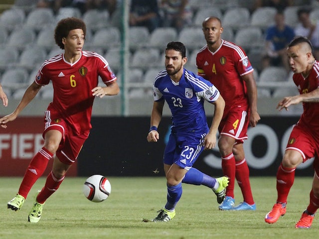 Belgium's Axel Witsel (L) runs with the ball as Cyprus' Marios Nikolaou (C) defends during the EURO 2016 qualifier football match between Cyprus and Belgium at the Neo GSP stadium in the Cypriot capital, Nicosia, on September 6, 2015.