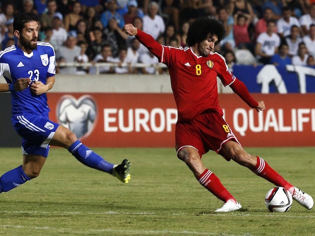 Belgium's Marouane Fellaini (R) dribbles the ball as Cyprus' Marios Nicolaou defends during their EURO 2016 qualifying football match between Cyprus and Belgium at the Neo GSP stadium in the Cypriot capital Nicosia on September 6, 2015. 