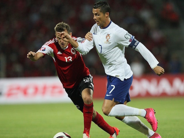 Albania's Burim Kukeli (L) vies with Portugal's Cristiano Ronaldo (R) during the Euro 2016 qualifying football match between Albania and Portugal at the Elbasan Arena in Elbasan on September 7, 2015.