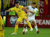 Claudiu Keseru (L) of Romania vies for the ball with Sokratis Papastathopoulos (R) of Greece during the UEFA Euro 2016 qualifying football match between Romania and Greece, in Bucharest, Romania on September 7, 2015.