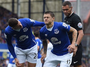 Everton's Ross Barkley tends to injured teammate Muhamed Besic during the game with Chelsea on September 12, 2015