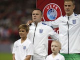 Romeo Beckham, son of former England footballer David Beckham, stands with England's striker Wayne Rooney as the team sing the national anthem ahead of the Euro 2016 qualifying group E football match between England and Switzerland at Wembley Stadium in w